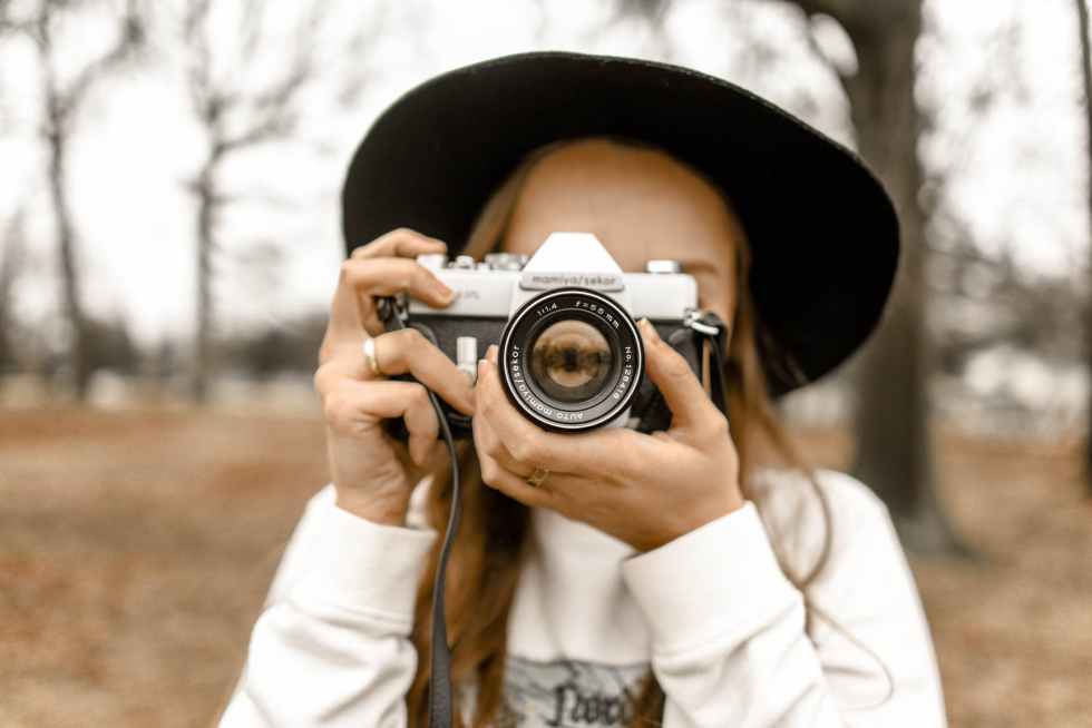 selective focus photography of woman using white and black slr camera