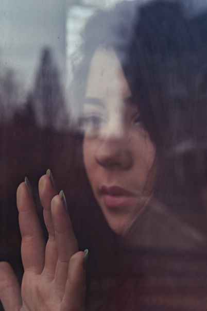 shallow focus photo of woman touching window